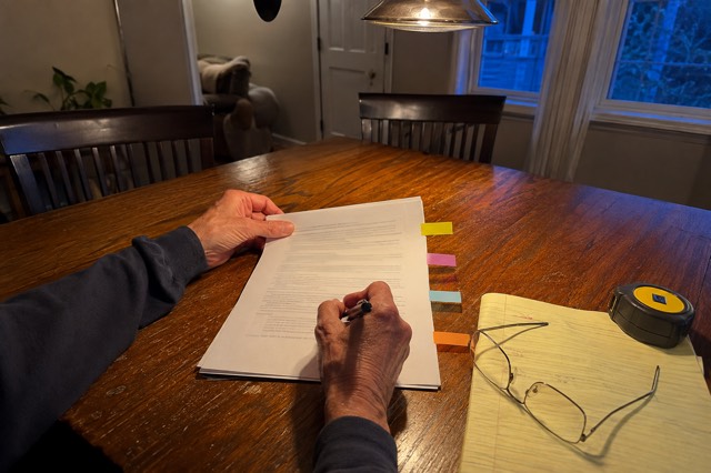 A homeowner uses blank colored tabs while reviewing a home-improvement contract