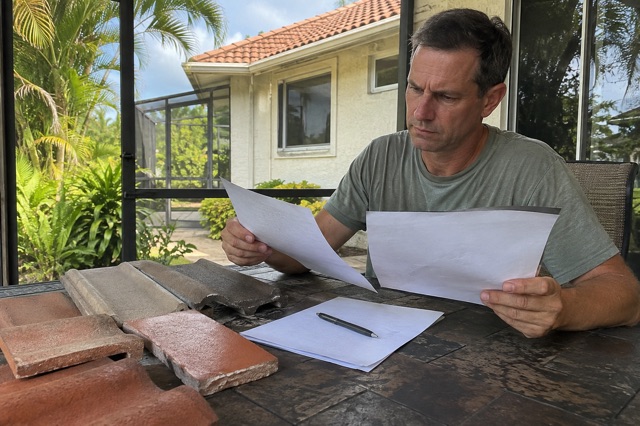 A homeowner compares contractor proposals beside clay and concrete roof tile samples